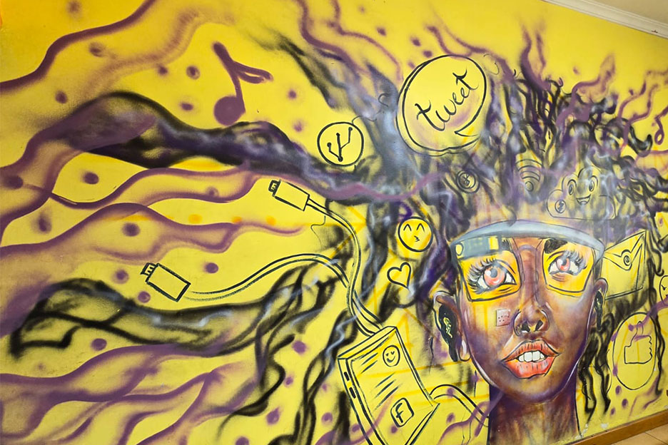 Wandbild im Nairobi Community iHub symbolisiert die Verbindung junger Frauen mit Technologie, Wissen und Empowerment.