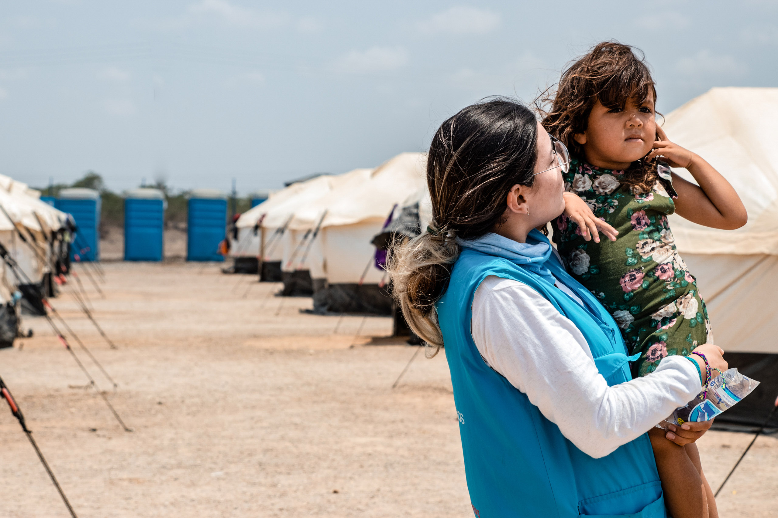 Mitarbeiterin der SOS-Kinderdörfer hält Kind auf dem Arm, zeigt die humanitäre Hilfe der SOS-Kinderdörfer