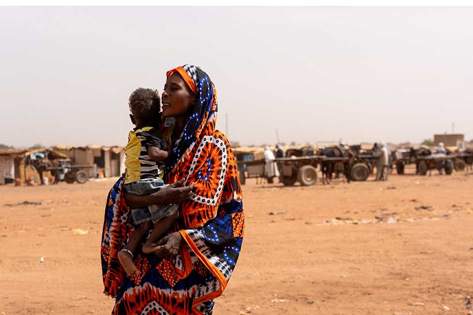 Geflüchtete aus dem Sudan im Tschad: Sie läuft mit ihrem Baby auf dem Arm durch die Stadt Adrem