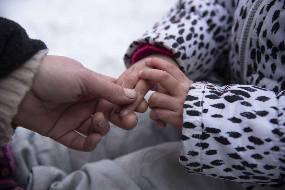Zwei Kinderhände halten sich fest 