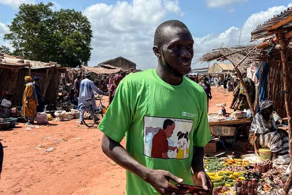 Boubacar Tarawali, Sozialarbeiter der SOS-Kinderdörfer in Gambia, geht über den Markt. Foto: Theresa Hirsch