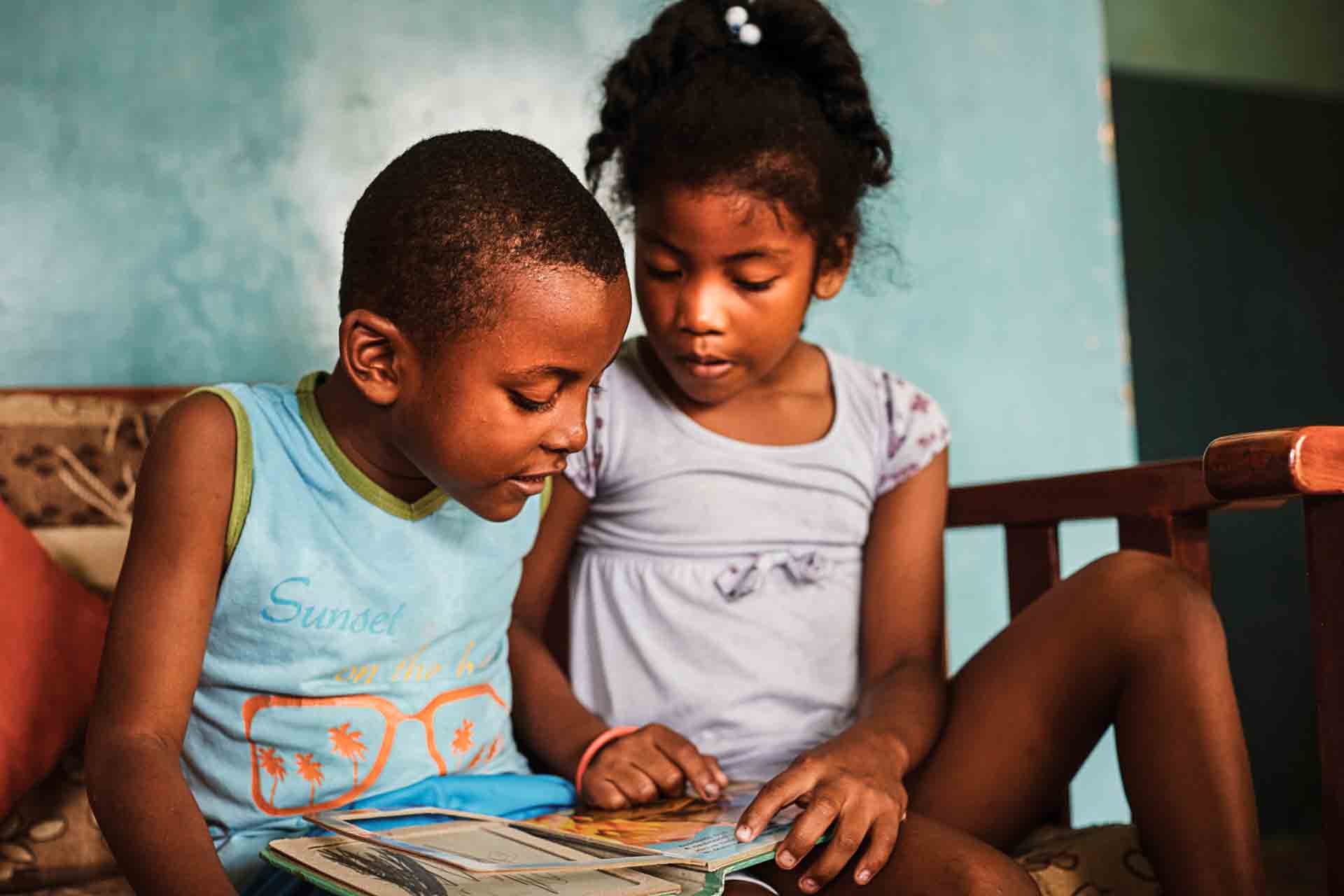SOS-Kinder in Ecuador sehen gemeinsam ein Buch an. Foto: Jens Honore