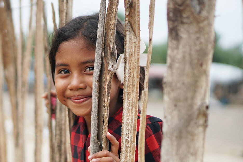 Mädchen blickt durch einen Zaun. Foto: Juan Serrano