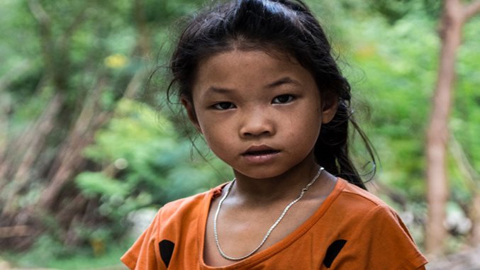 Mädchen in Vietnam vor Bäumen und Büschen