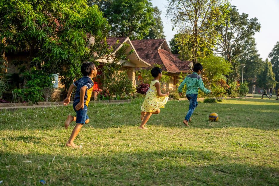 Spielende Kinder auf einer Wiese im Kinderdorf 