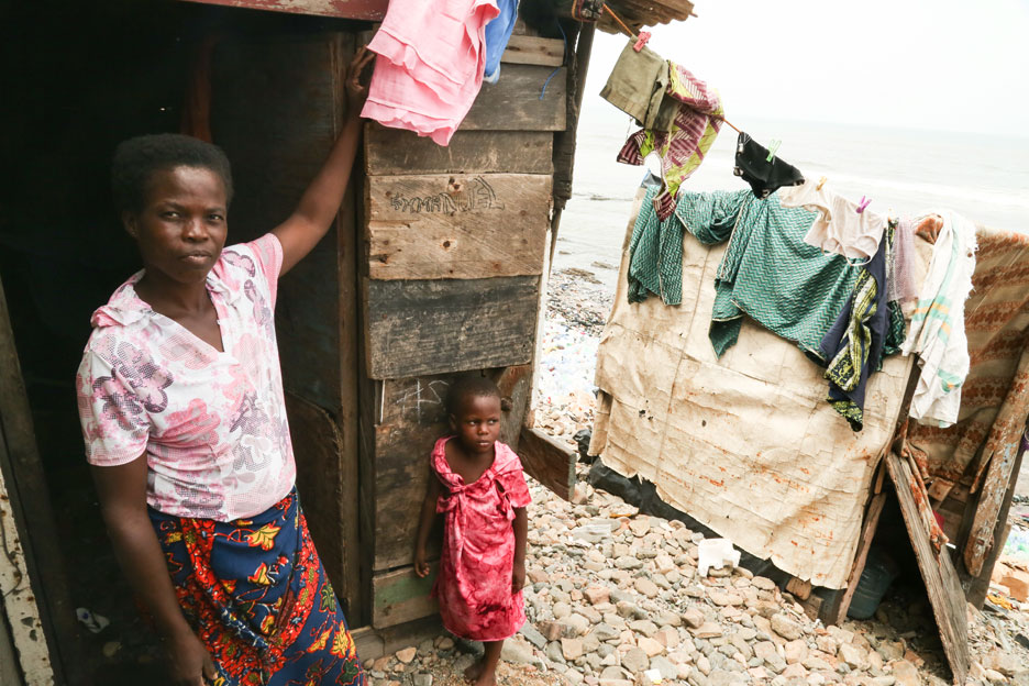 Mutter mit KInd vor ihrer Hütte in Ghana. Foto: Tom Maruko