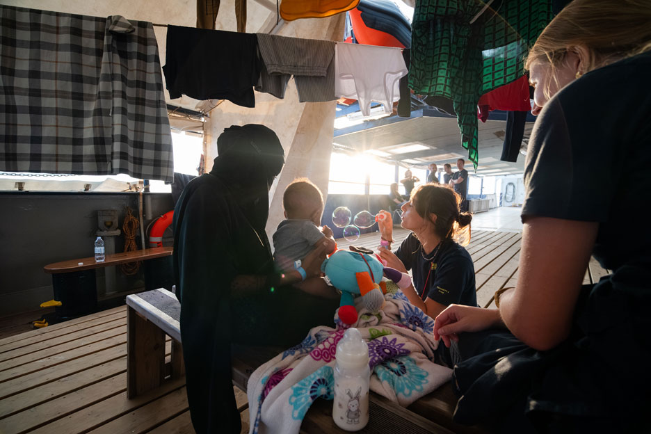 Helferinnen betreuen eine geflüchtete Mutter und ihr Baby auf einem Schiff. Foto: Camilla Kranzusch / SOS Humanity