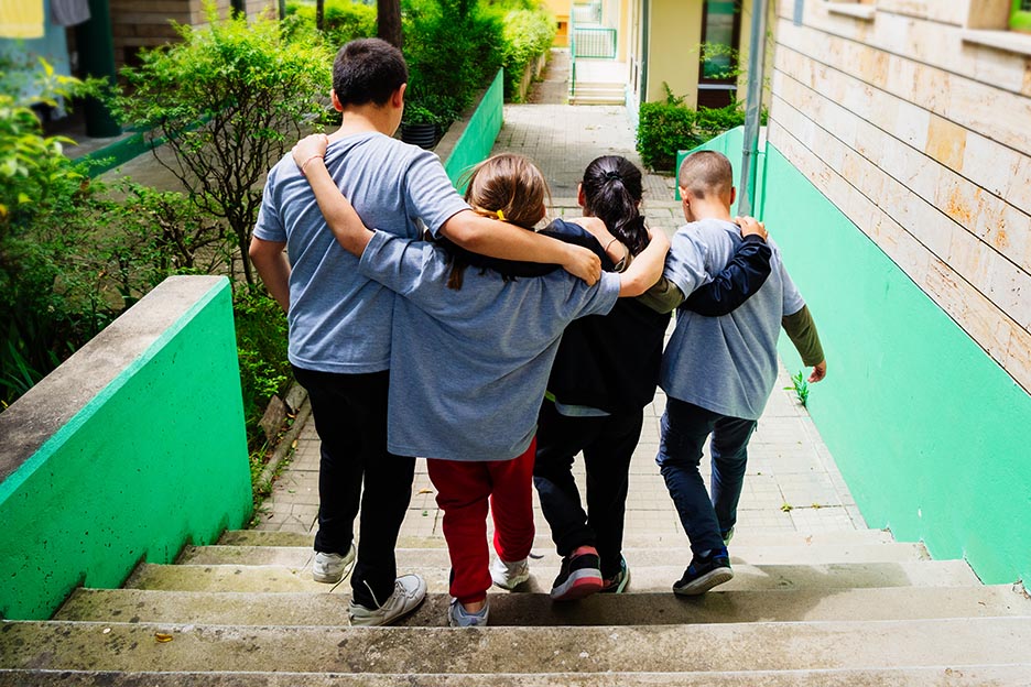 Kinder gehen Arm in Arm eine Treppe herunter