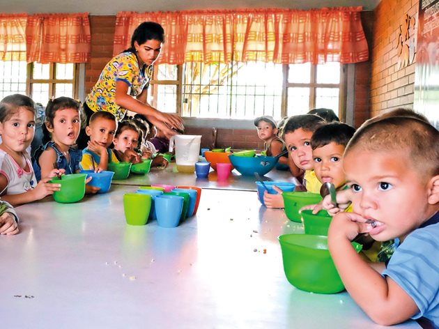 SOS-Mitarbeiterin versorgt Kinder im SOS-Sozialzentrum Lagunillas.