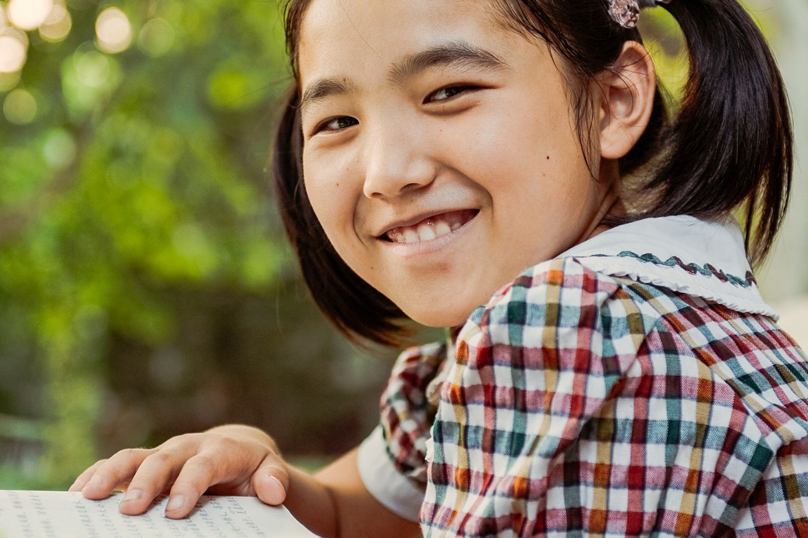 Ein Mädchen aus China blickt freudig in die Kamera.