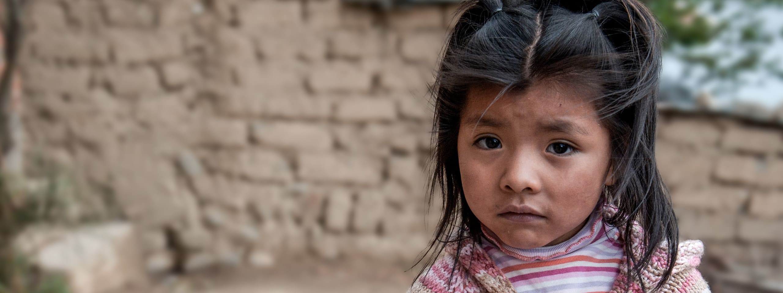 Mädchen aus Bolivien blickt traurig in die Kamera.