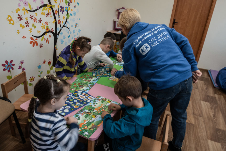 Kinder sitzen am Tisch und basteln