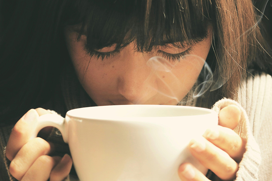 Frau mit einer dampfenden Tasse Tee