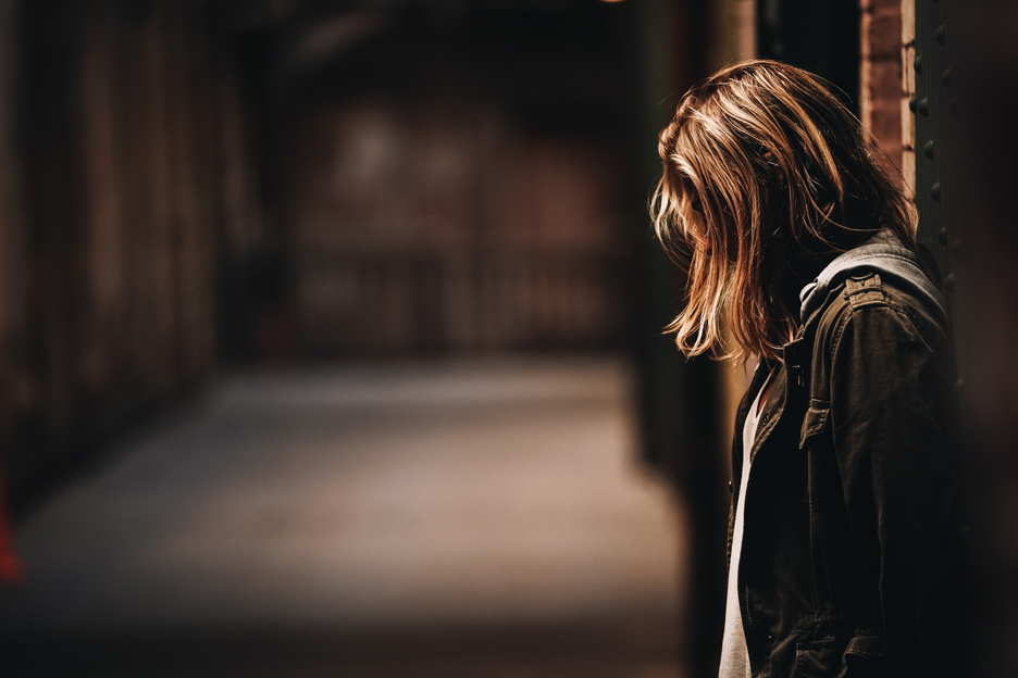 Junge Frau mit gesenktem Kopf.