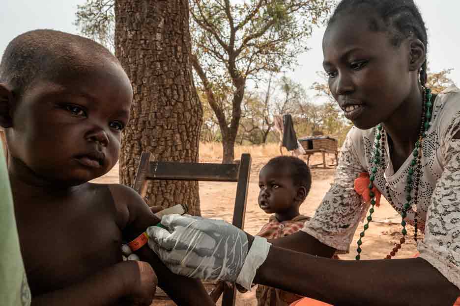 Eine Helferin im Südsudan untersucht ein Kind auf Mangelernährung