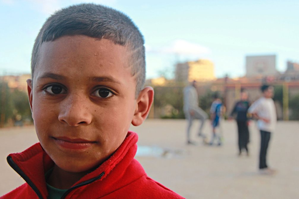 Auf dem Sportplatz ist Sirah (10) am liebsten. Wenn er mit demTrainer und den anderen Jungs im SOS-Kinderdorf bei Damaskus herumtollt, kann er die schmerzhaften Erinnerungen vergessen. Seine leiblichen Eltern kamen bei einem Bombenangriff ums Leben. Foto: Philipp Hedemann