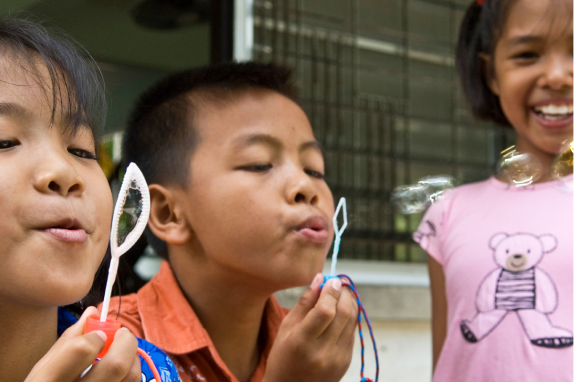 Kinder spielen mit Seifenblasen