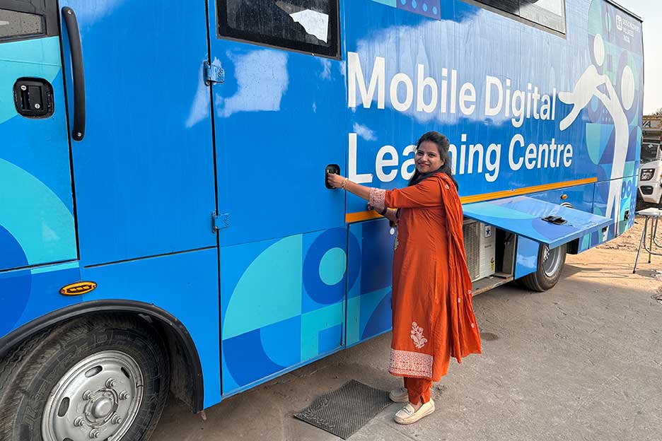 Pooja Gupta, Sozialarbeiterin der SOS-Kinderdörfer, vor dem Digitalen Lernbus der SOS-Kinderdörfer