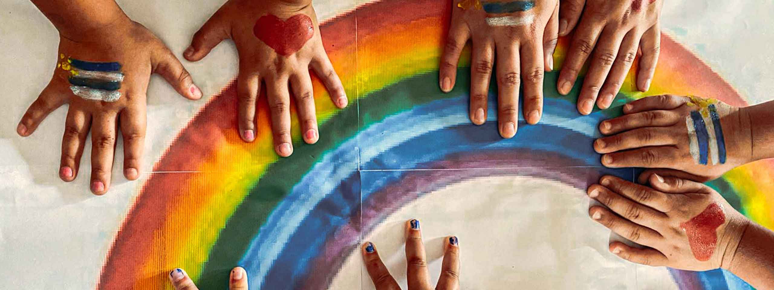Kinderhände auf Regenbogen