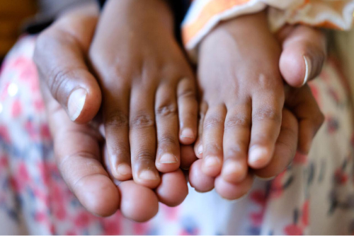 Kinderhände auf Erwachsenenhände