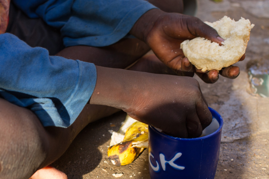 Kind im Suedsudan beim Essen, Fokus auf Hände