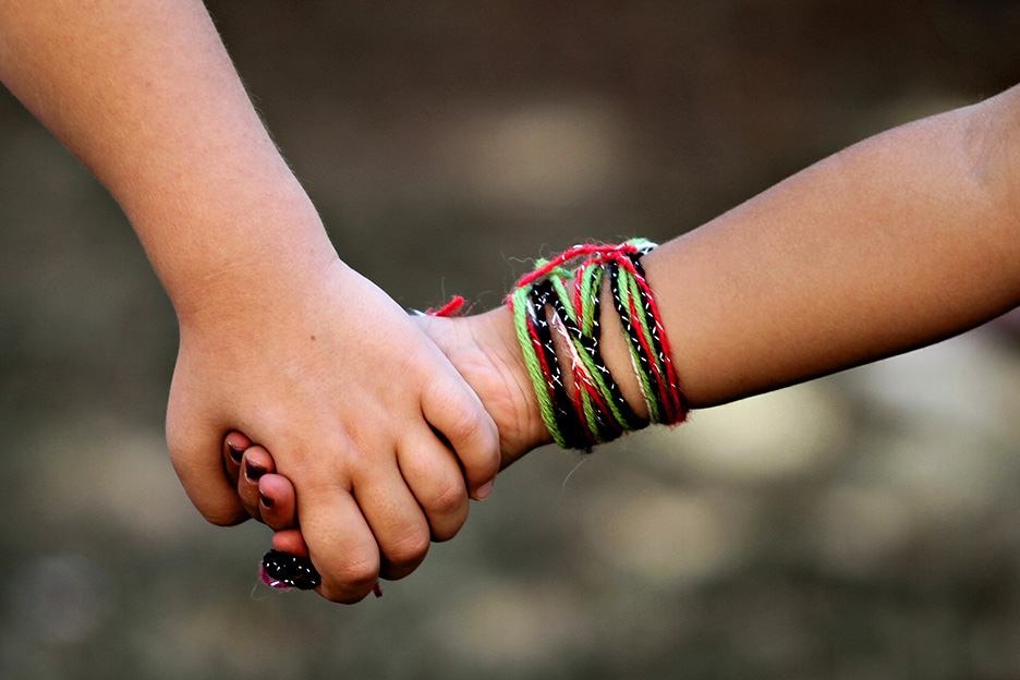 Zwei Kinderhände halten sich