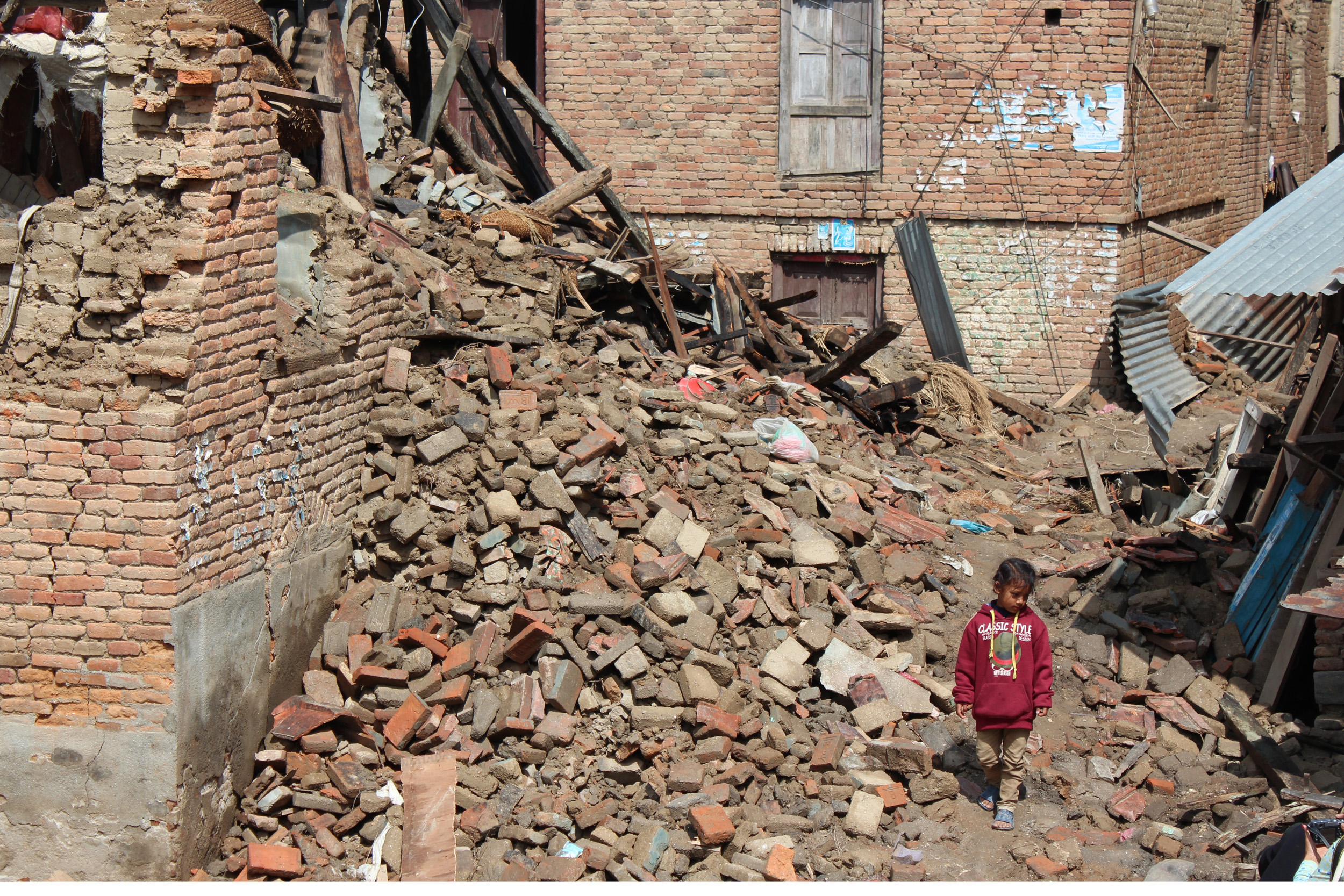 Kind in Ruinen nach Erdbeben in Nepal