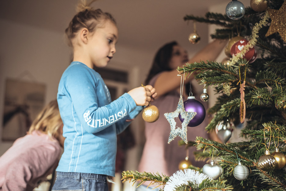 Mädchen beim Christbaum schmücken