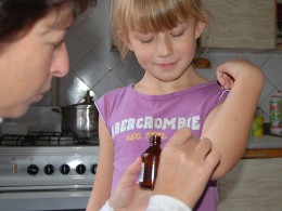 Mädchen im SOS-Kinderdorf Brovary nimmt ein Medikament ein.