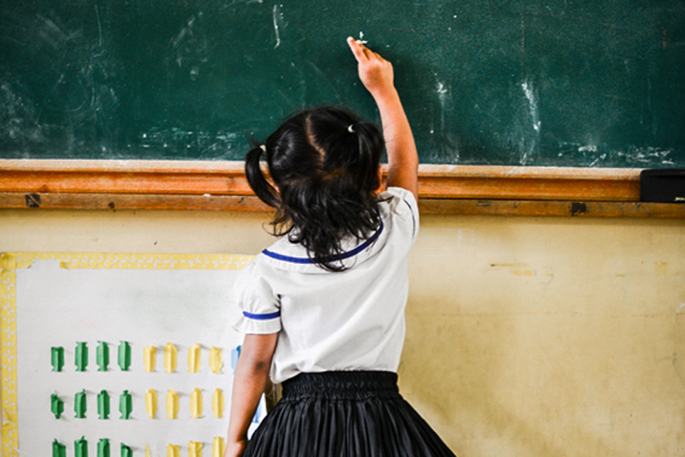 Kind schreibt an Tafel