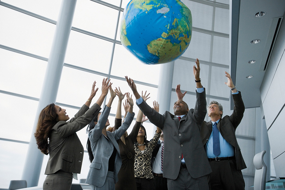 Mitarbeiter werfen einen Weltkugel-Ball