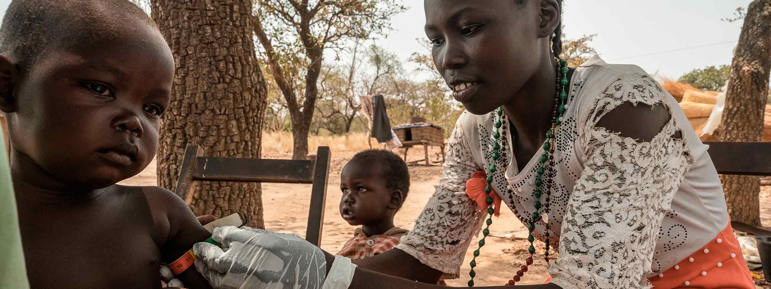 Eine Helferin im Südsudan untersucht ein Kind auf Mangelernährung