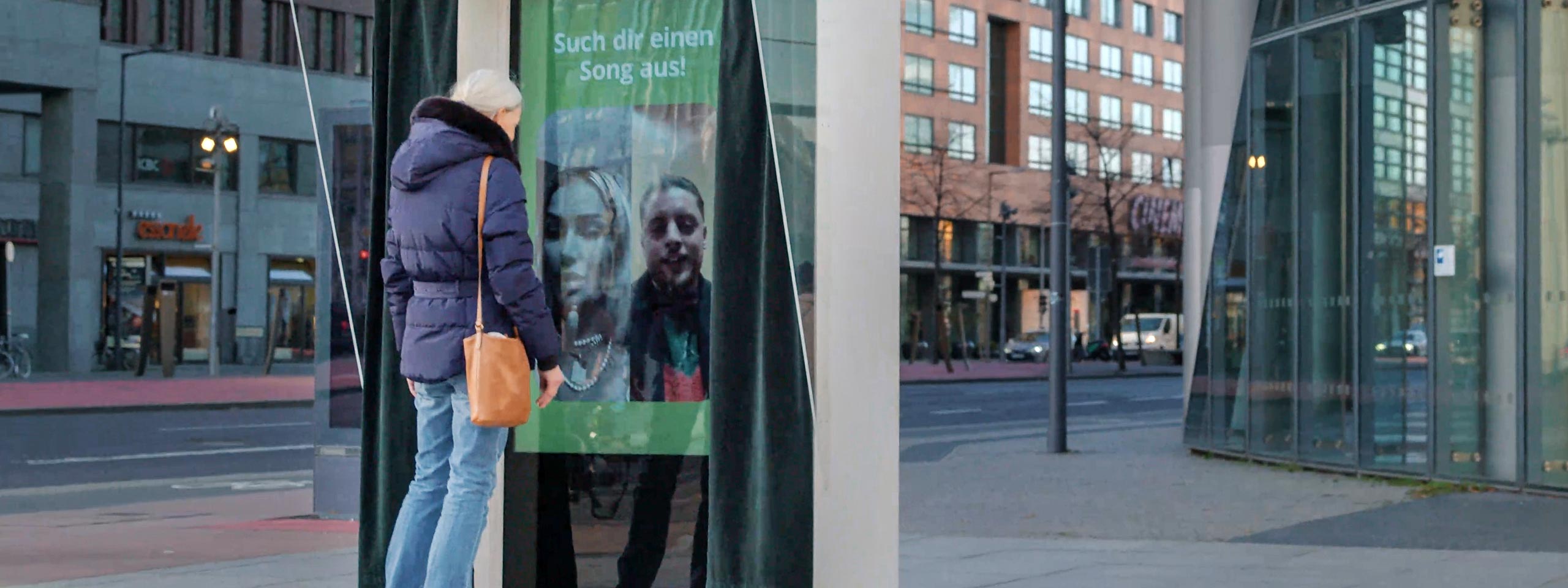 Berlin: Passantin vor Videoscreen
