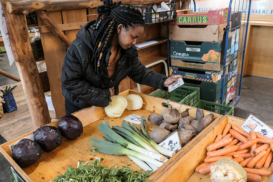 Studentin Genet aus Äthiopien wählt in einer Markthalle Gemüse aus. Foto: SOS-Kinderdörfer