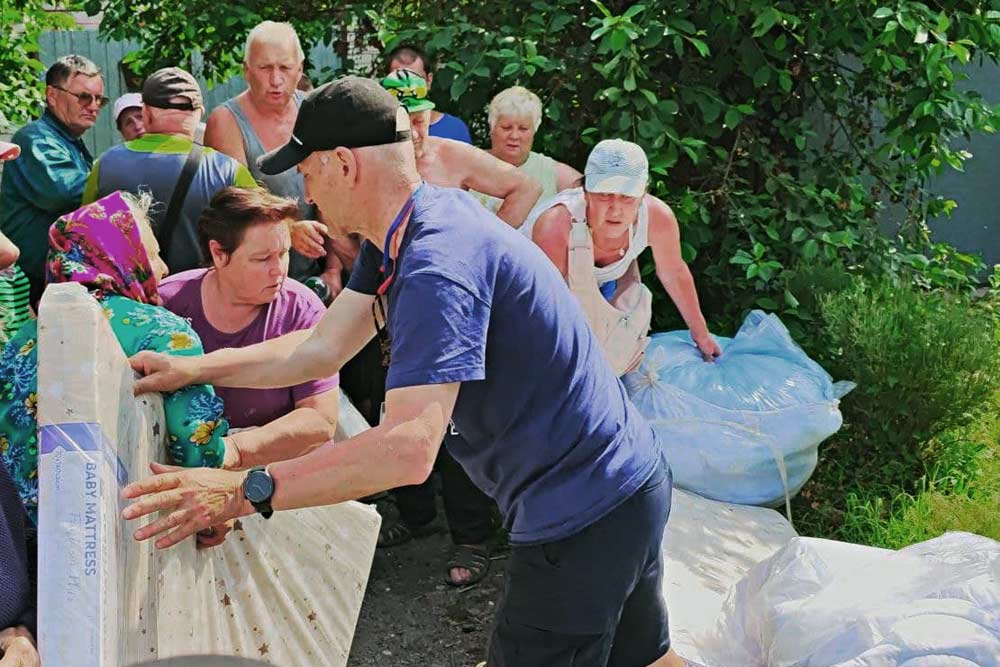 Nach Dammbruch in der Ukraine: Helfer verteilen Hilfsgüter an Familien. Foto: Pomagaiem