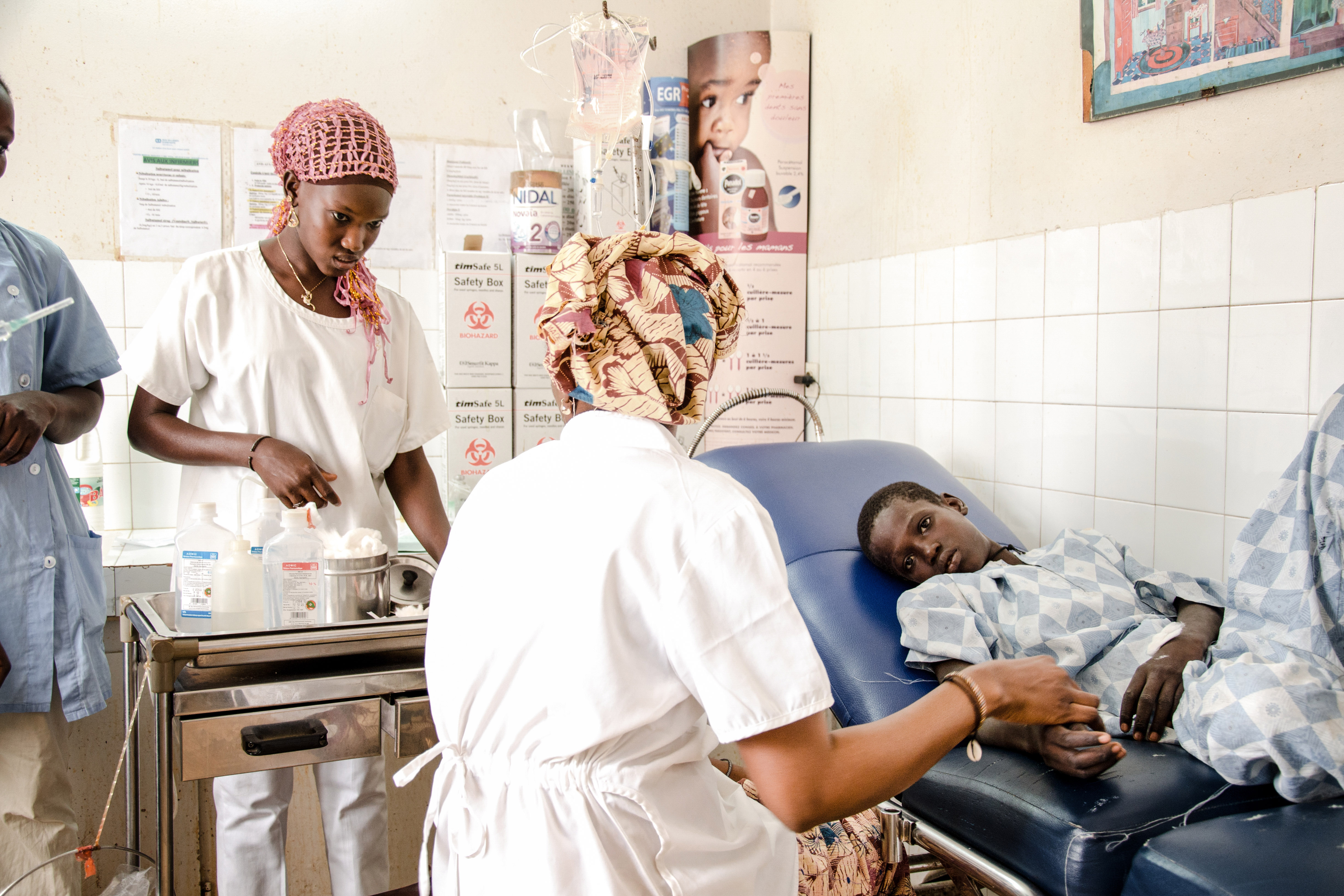 Krankenschwestern versorgen ein Kind: 18.000 Patienten jährlich werden im SOS-Zentrum in Kaolack, Senegal, behandelt.