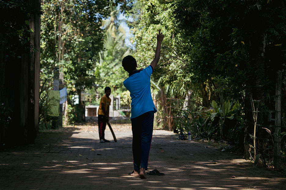 Jungen spielen Cricket zwischen Bäumen. Foto: Martin Hanebeck