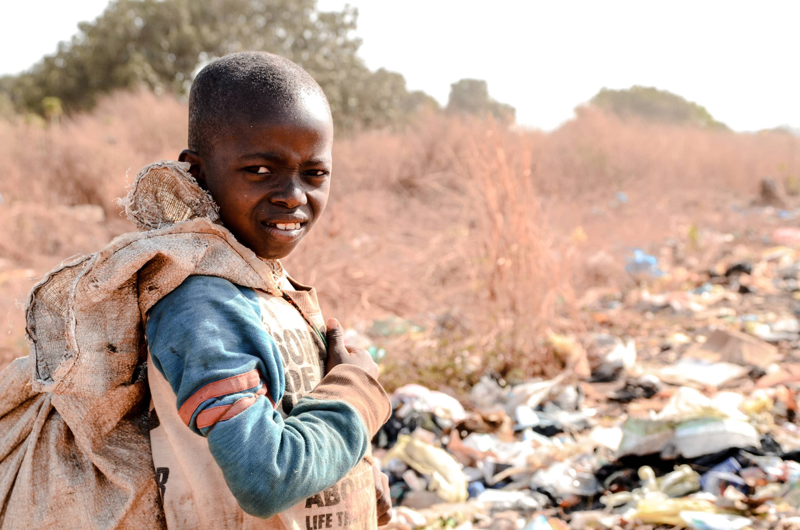Ein Junge leidet unter Kinderarbeit und sammelt Müll in Conakry, Guinea.