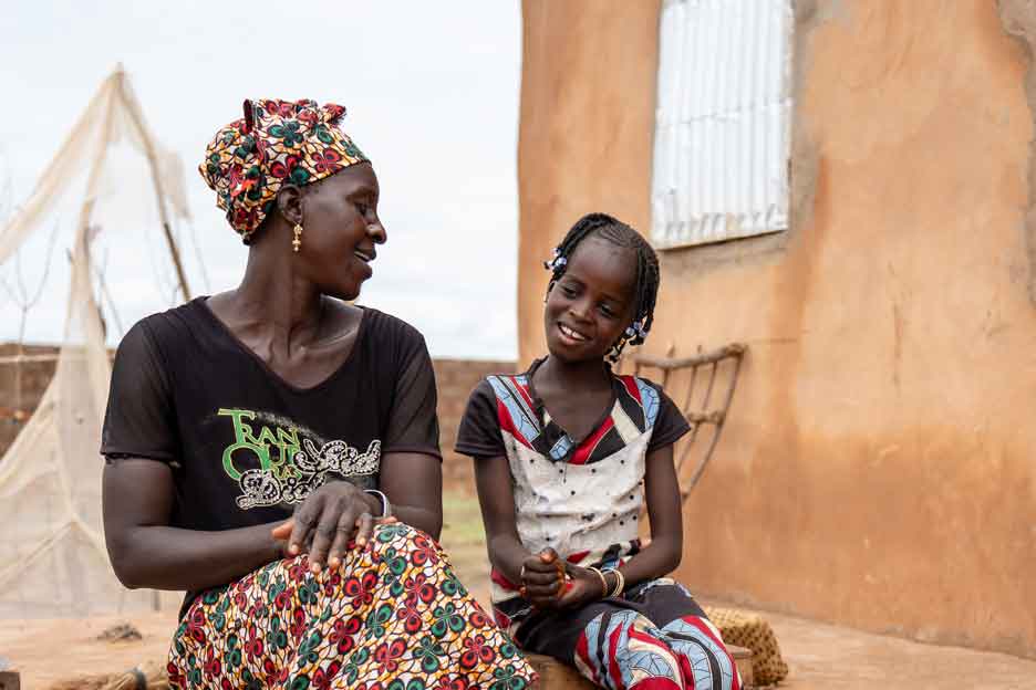 Dador und ihre Tochter sitzen vor ihrem Haus und lachen - Foto: Jakob Fuhr