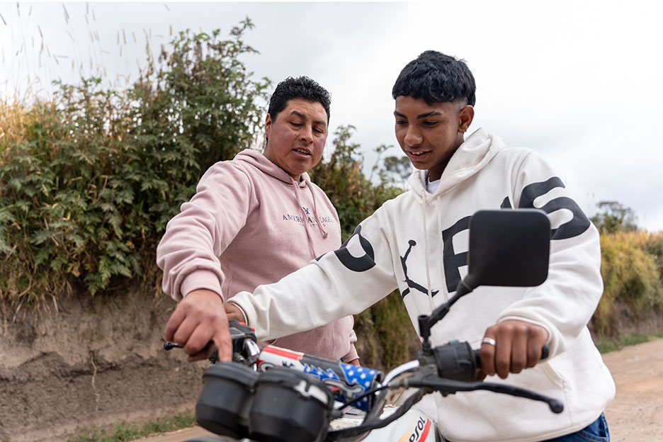 Pflegevater und Pflegesohn basteln zusammen am Motorrad. Foto: Jakob Fuhr