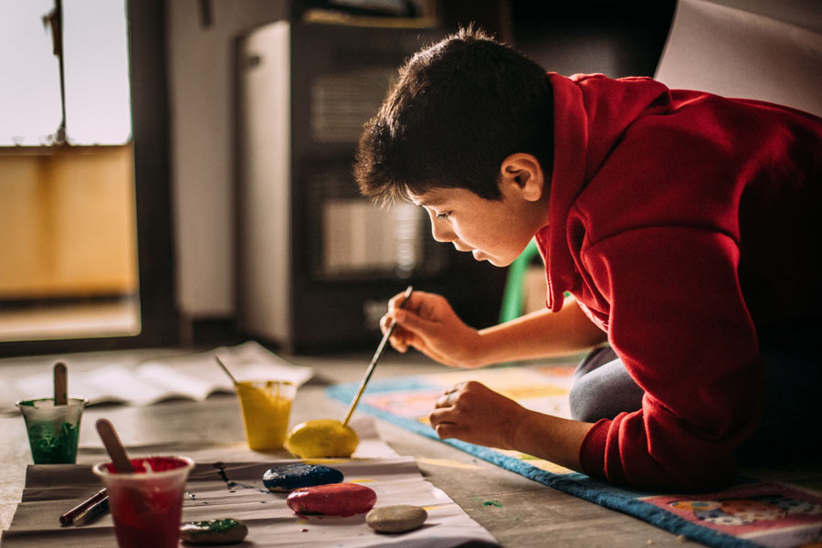 Junge bemalt Steine. Foto: Alea Horst