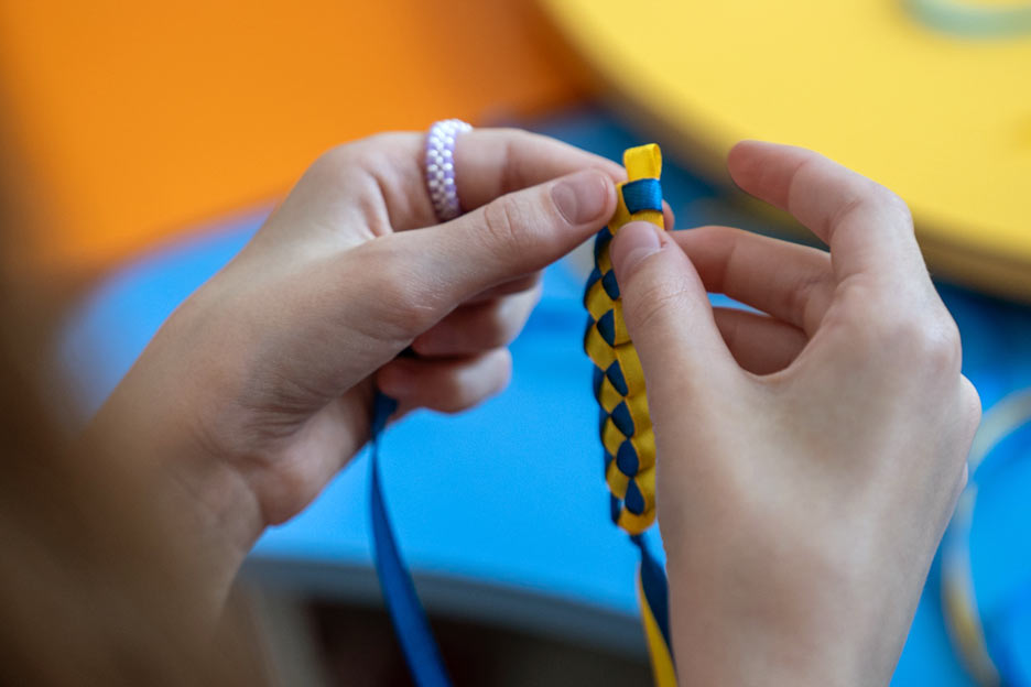 Hände flechten ein Band. Foto: Oleksandra Zborovska