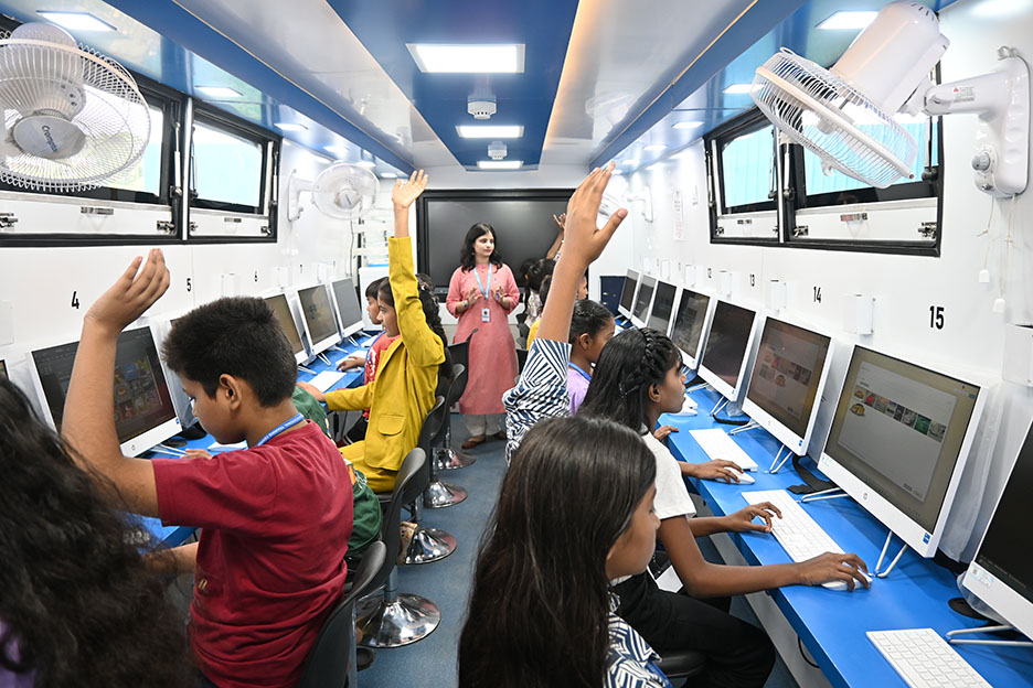 Kinder lernen an Computern in einem Lernbus in Indien.