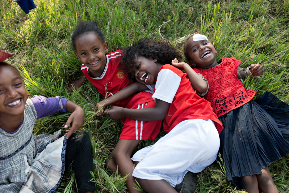 Kinder spielen im Gras
