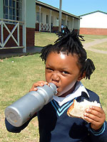 Unterrichtspause an der SOS-Schule in Umtata: Ein Mädchen lässt sich sein Pausenbrot schmecken.