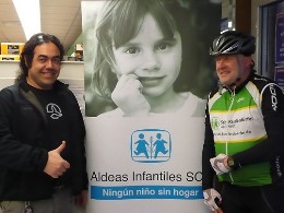 Martin Glowacki neben einem SOS-Kinderdorf-Plakat