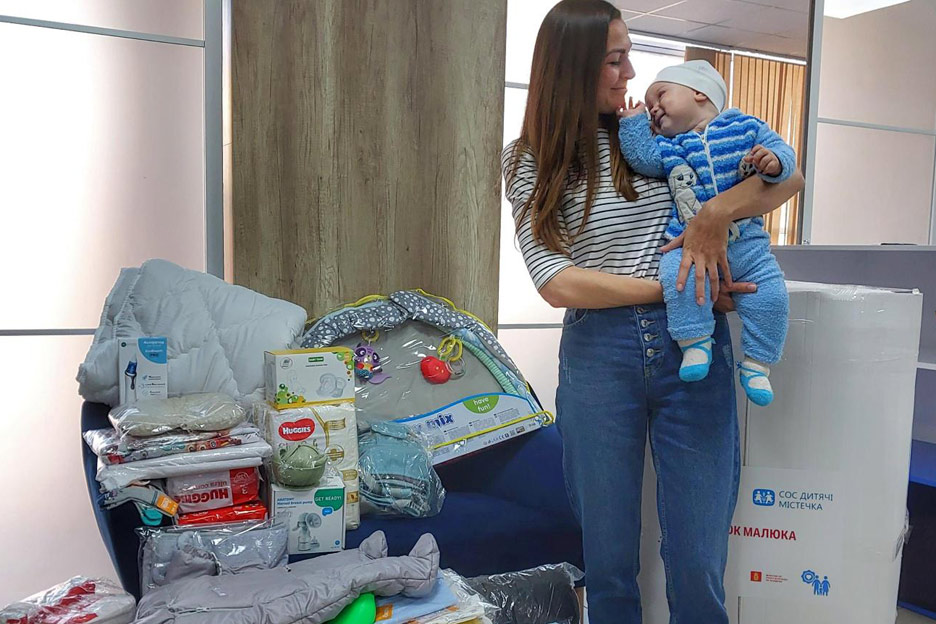 Eine Mutter freut sich über eine Erstausstattung für ihr Baby. Foto: SOS-Kinderdorf Ukraine