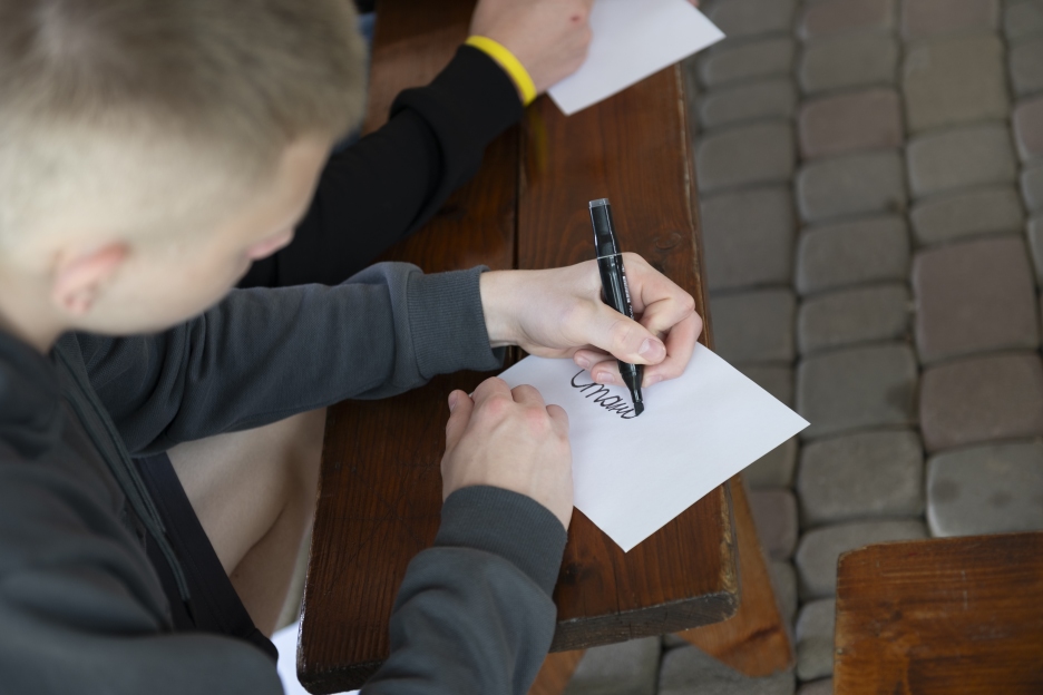 Jugendlicher schreibt an einer Schulbank