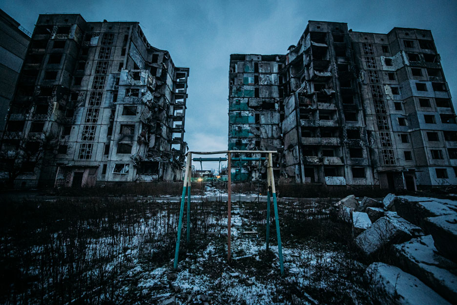 Spielplatz vor zerstörter Häuserreihe in Borodianka in der Ukraine.