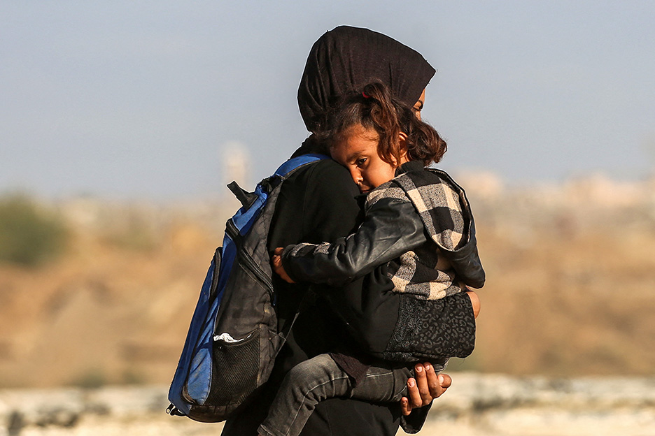 Eine Mutter in Palästina trägt ihre Tochter auf dem Arm. Foto: AFP / Eyad Baba